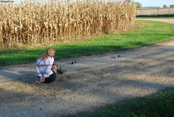 Chica atada y amordazada en el camino del bosque