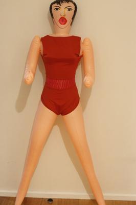 Boneca asiática vestindo um maiô vermelho