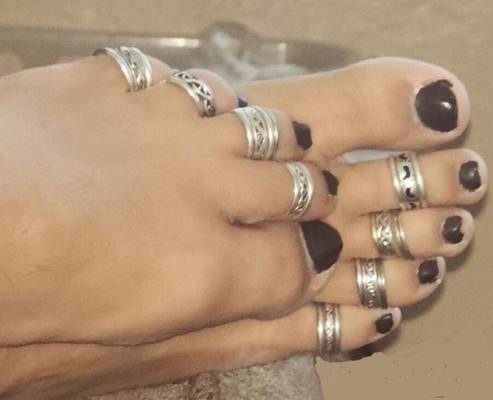 Esmalte de uñas negro con anillos en los dedos de los pies.