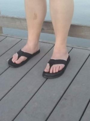 Pies de esposa en chanclas en el lago por sus comentarios