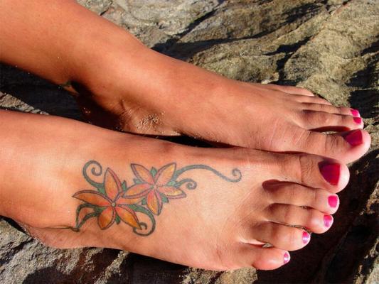 Pés tatuados sexy com unhas pedicuradas