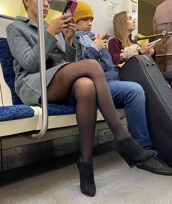 Mulher de meia-calça e botins de camurça no metrô