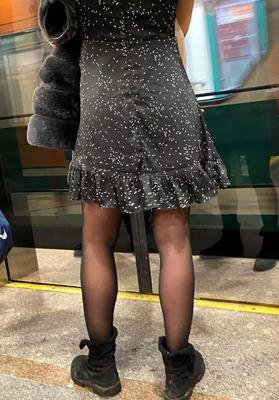 Mädchen in schwarzen Strumpfhosen und Kleid in Metro